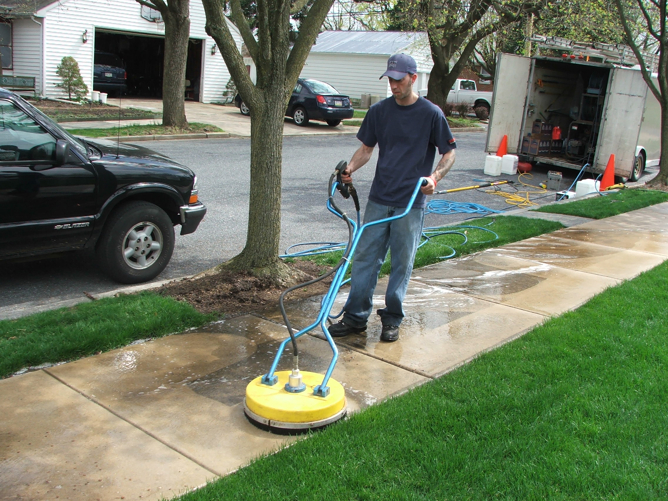 Pressure washing of sidewalks using a flat surface cleaning equipment.